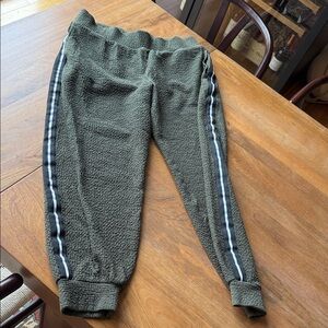 SweatyBetty Jogger Pants - Olive Green with black and white grosgrain stripes.